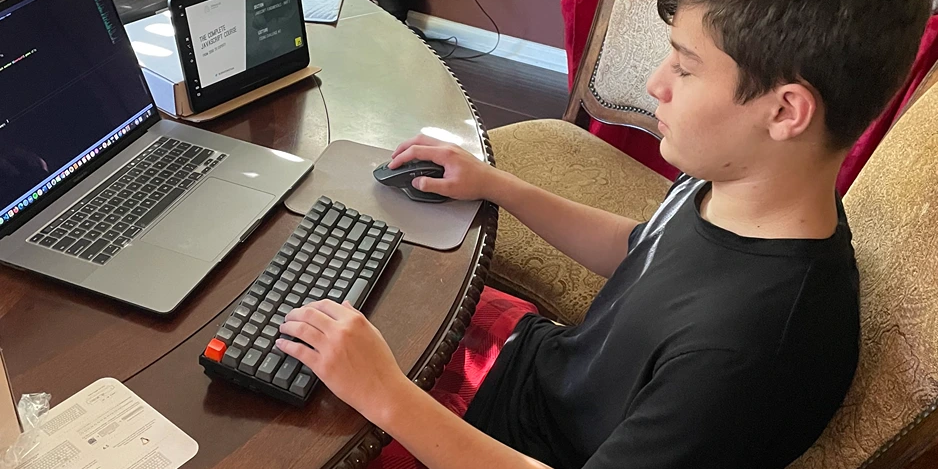 Noah coding at a desk during the holidays.